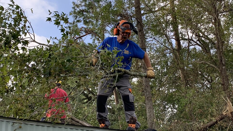 rocky mize works on a chainsaw team after hurricane laura